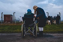zdjęcie ilustracyjne: od lewej osoba na wózku inwalidzkim, osoba stojąca